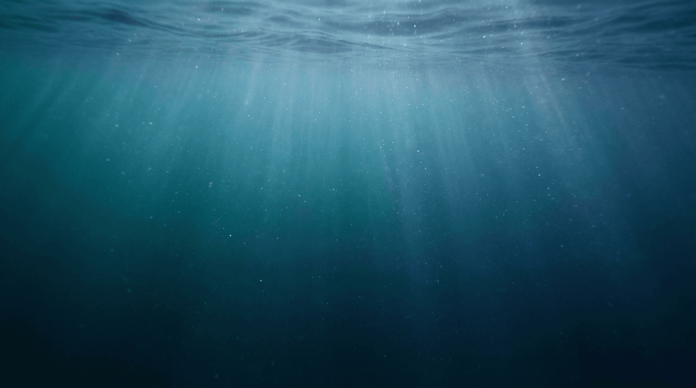 Serene underwater scene with sunlight filtering through ocean water and dancing particles.